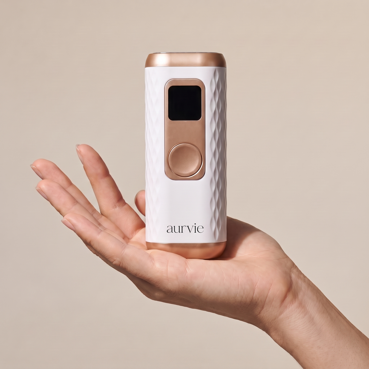 Aurvie IPL handset resting on an open palm to show its size (ALT)